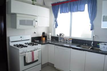 Open living and dining space with balcony overlooking Pacific ocean at Barcovento Penthouse Panama