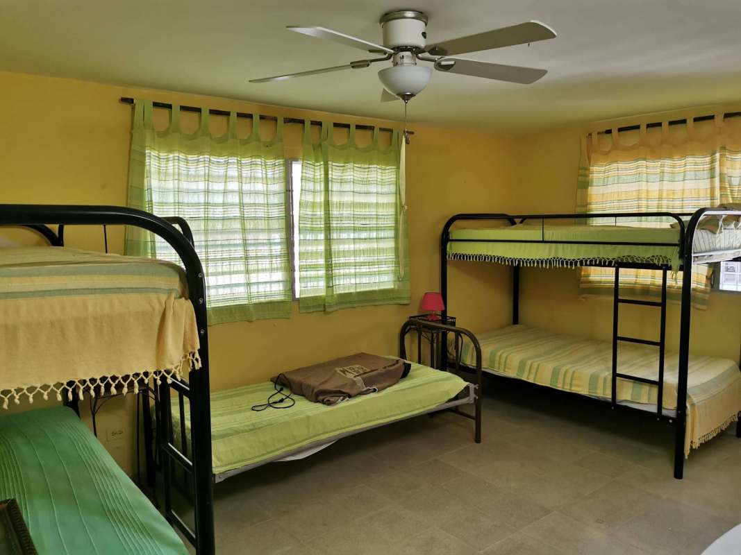 Covered porch with dining furniture, rustic decor, and lush garden at Santa Clara Panama