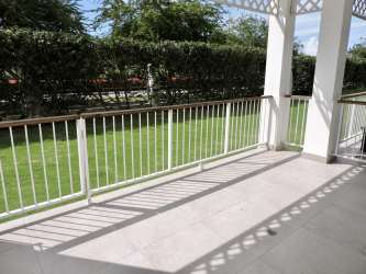 Balcony with outdoor seating overlooking garden area at Kite Village Punta Chame
