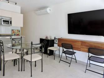 Dining area with glass table and TV in Punta Chame Kite Village beachfront apartment
