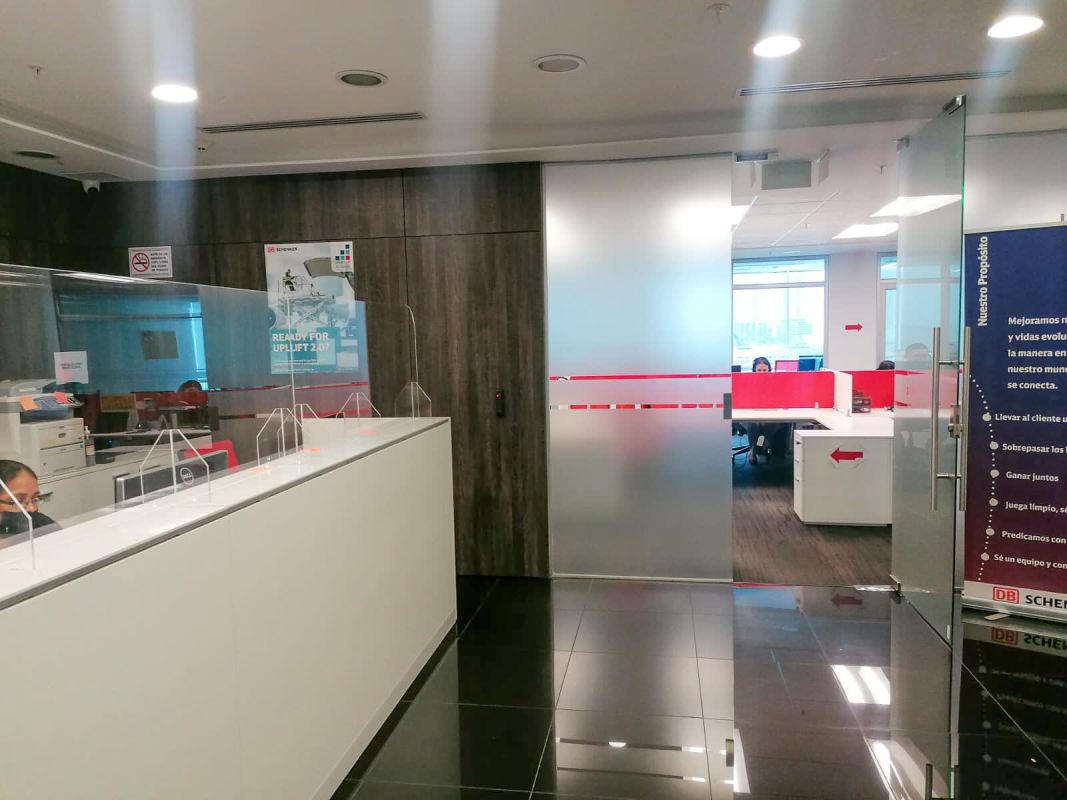 Modern office with glass walls, floor-to-ceiling windows overlooking city skyline in PH Plaza Real Costa del Este