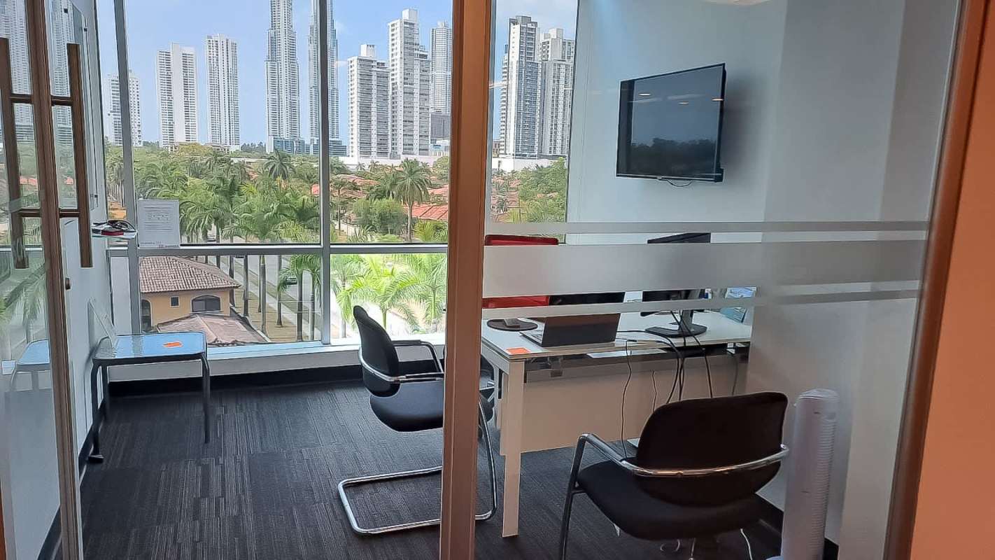 Corporate office interior with glass partition walls, shelving, and modern furniture in PH Plaza Real Costa del Este