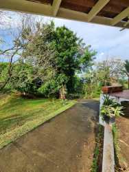 Large green garden with parked car and mountain views at Portobelo property Panama