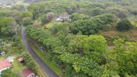 Aerial of house surrounded by dense forest, winding road, open clearings Portobelo Panama