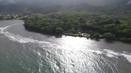 Double height living area with large grid windows, mezzanine railing, pendant lights in Portobelo