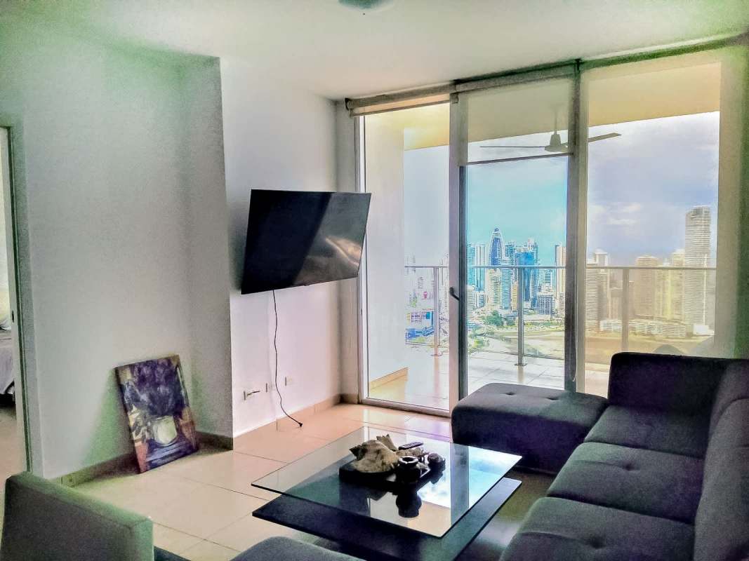 Living room with sofa set, glass coffee table, balcony city skyline view - PH White Tower Panama