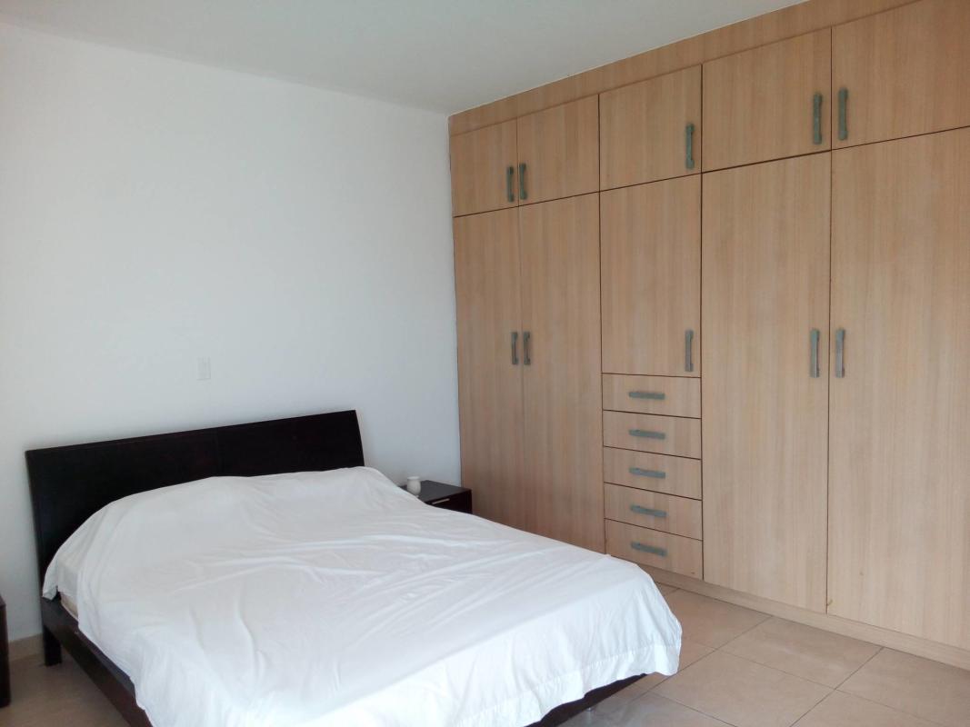 Bedroom with large window and panoramic city skyline view in PH White Tower Panama City