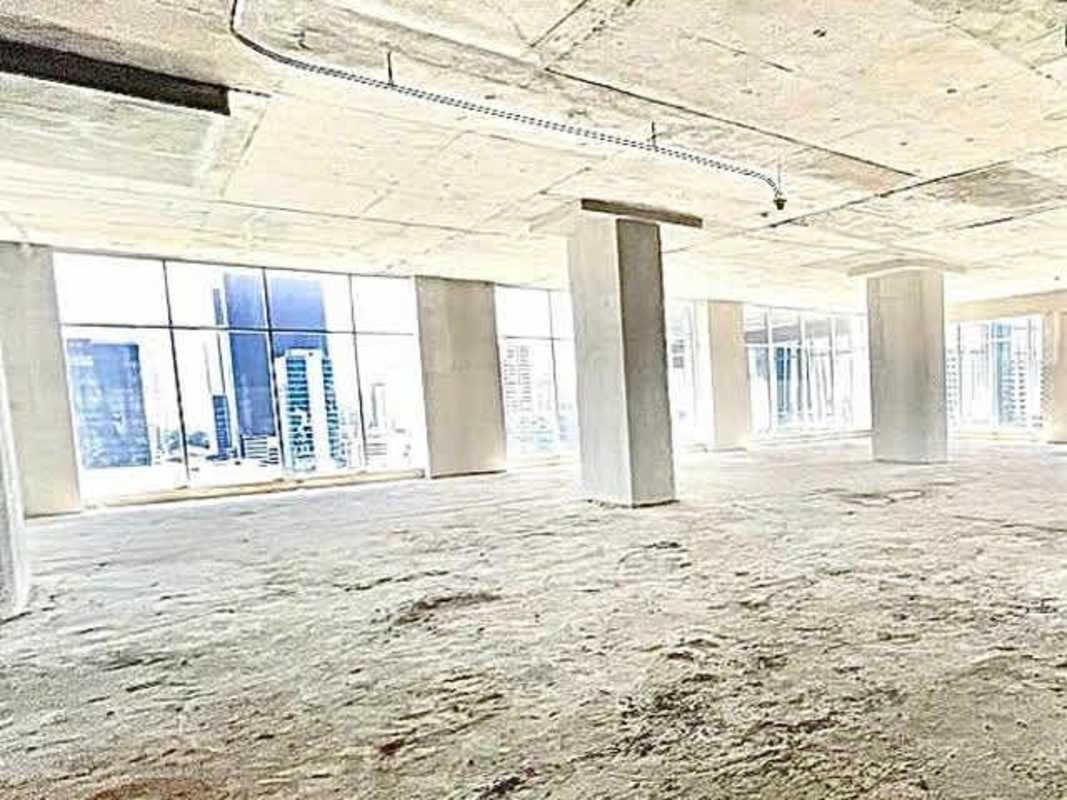 City skyline visible through large windows of unfinished commercial space in Revolution Tower Panama City