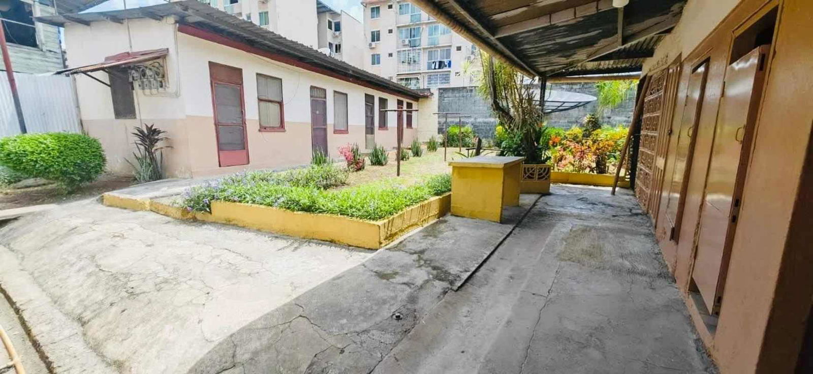 Fenced courtyard area with garden beds and external house view in Panama property
