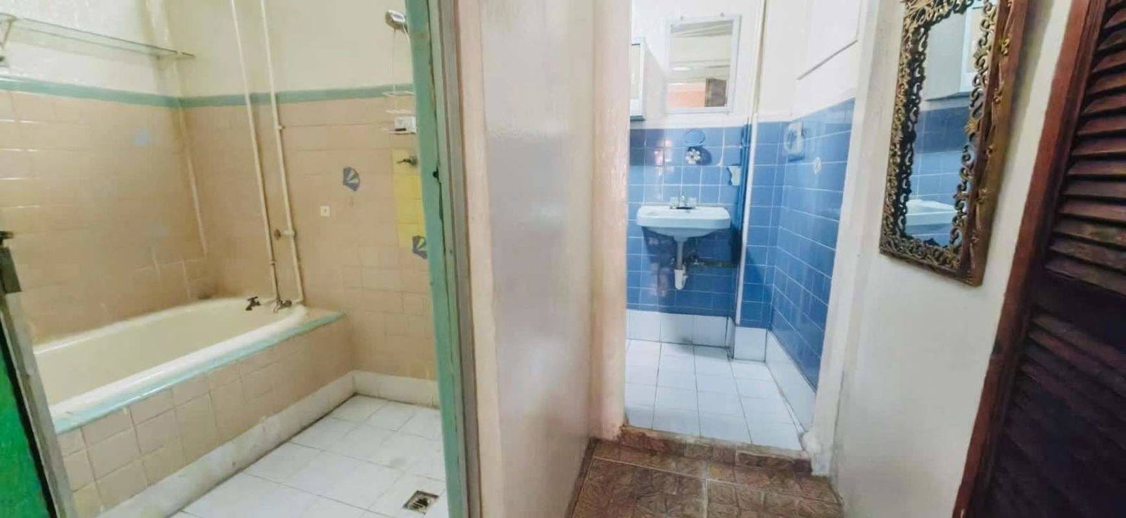 Vintage style bathroom with bathtub, ceramic tiles and vanity in commercial building Panama City