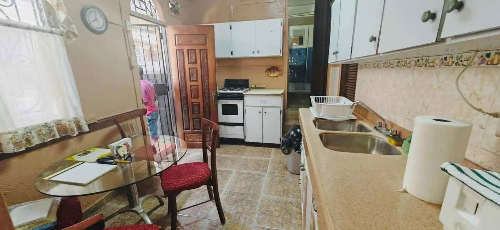 Large kitchen dining area with cabinets, sink and table in income property Panama City