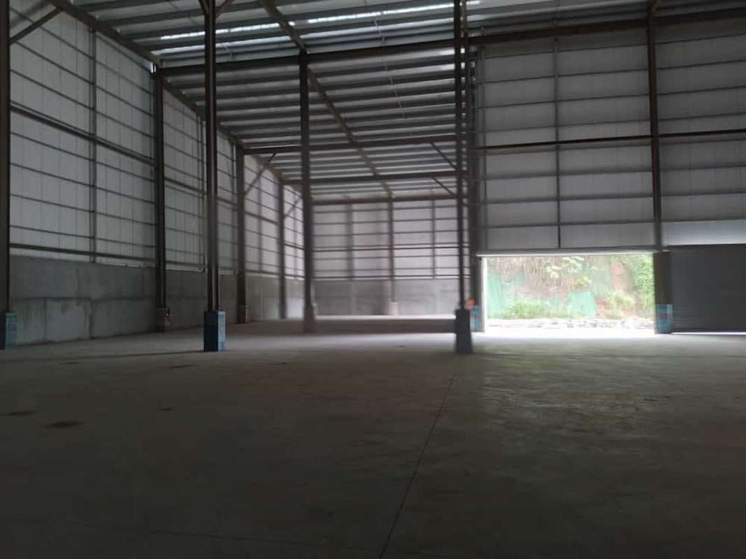 Large empty warehouse with high ceilings, metal support and concrete floor