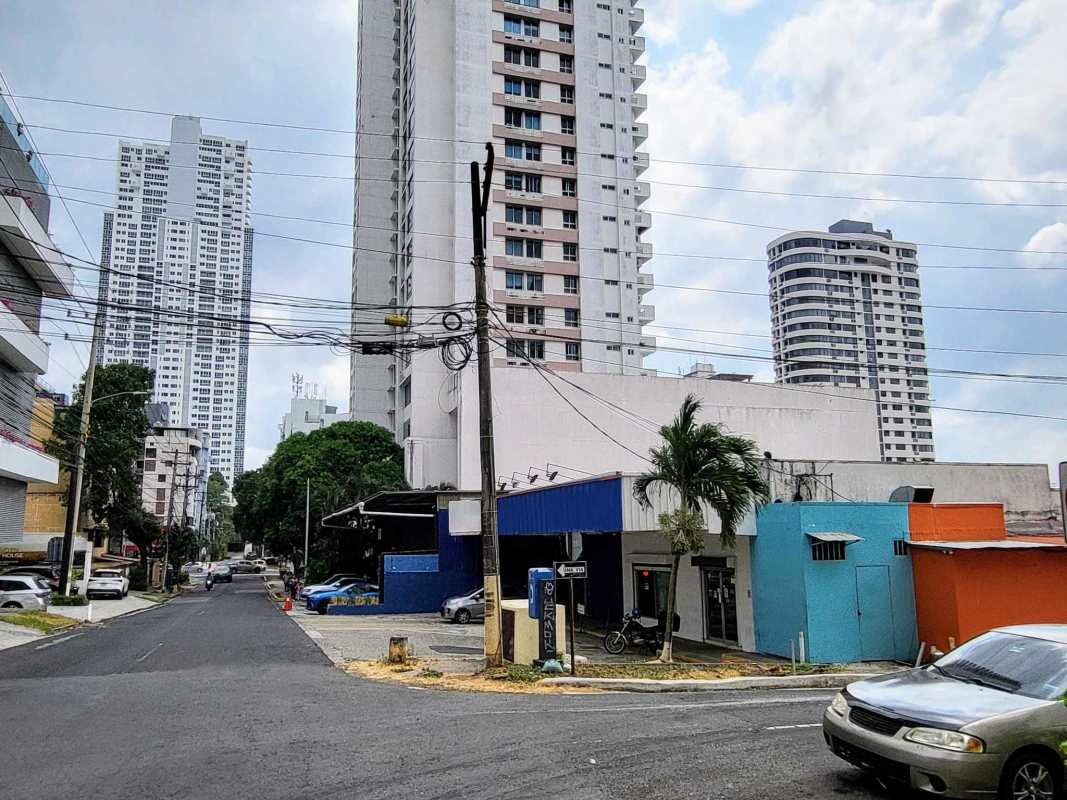 Mixed-use retail office buildings along busy Panama City commercial corridor with palm trees and traffic