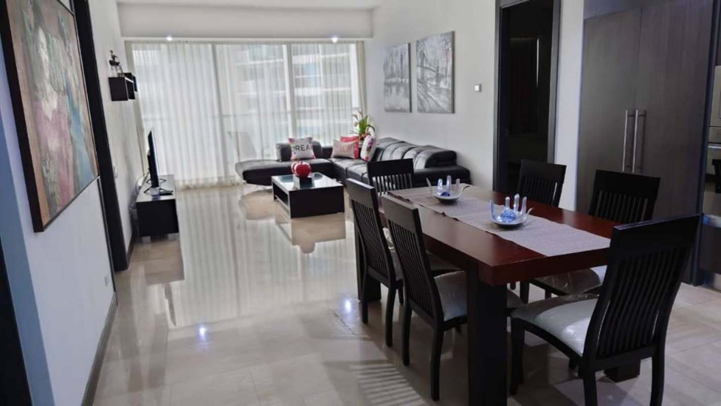 Open plan living dining area furnished with large windows ocean view at PH Aquamarina