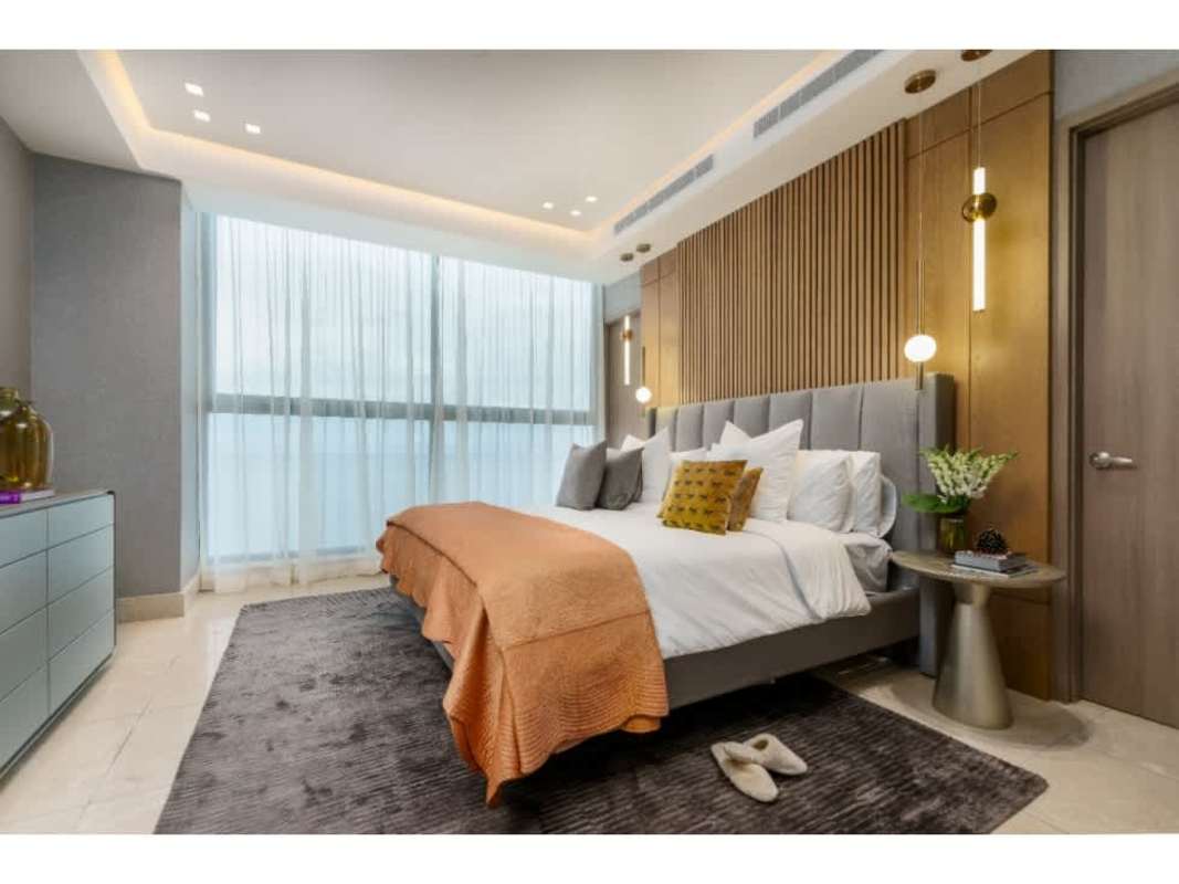 Master bedroom with large windows, upholstered bed and skyline view in PH Deluxe Residences Panama City