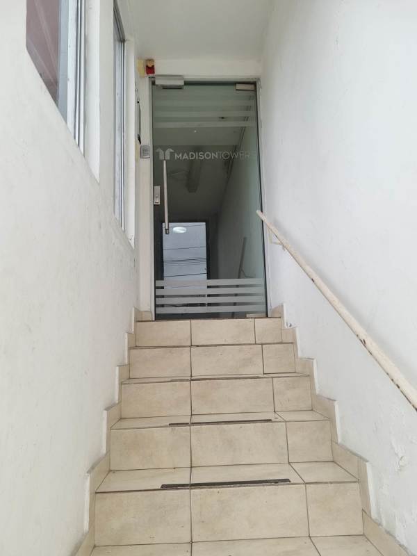 Tiled stairway with glass door leading to mezzanine level commercial unit at PH Madison Tower Panama City