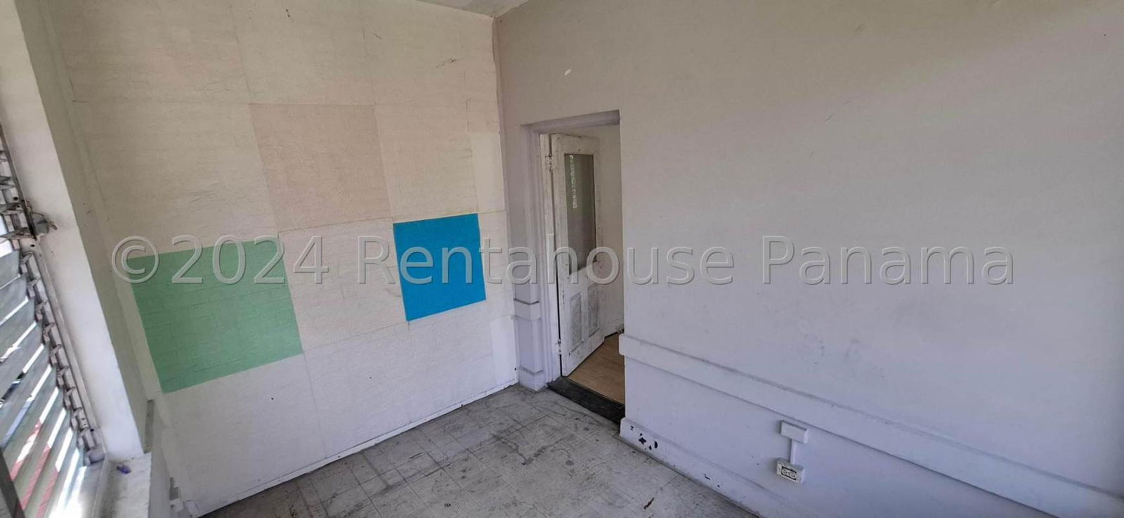 Exterior view of two-story white residential building with red tile roof and green gardens in Clayton Panama