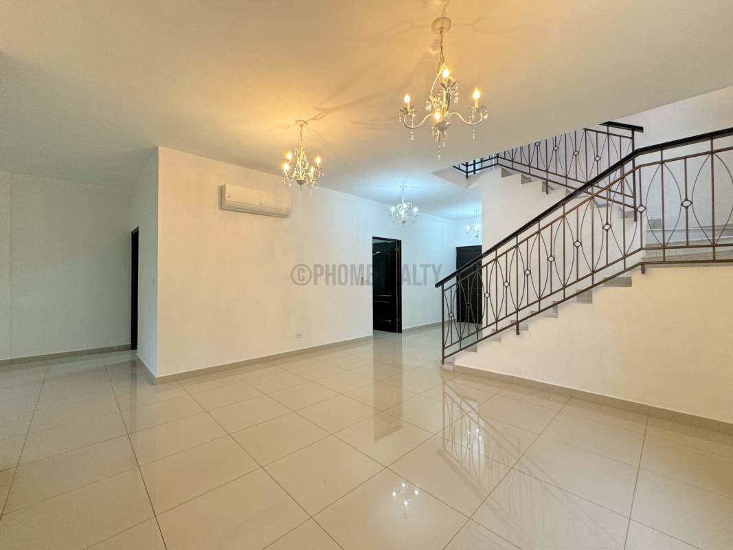 Bright living room with tile floors, chandeliers and staircase in Costa Sur house Panama