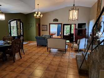 Spacious kitchen with island sink, wood cabinets, dining space in El Valle estate