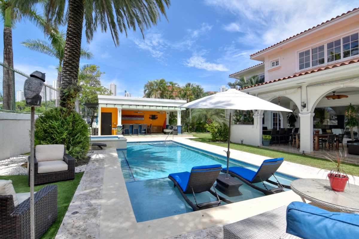 Outdoor pool area with sun deck, terrace, lush garden in exclusive Costa del Este home