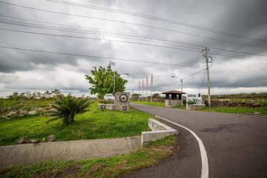 Front view of paved Pan-American Highway access and property gate in Alto Boquete, Panama