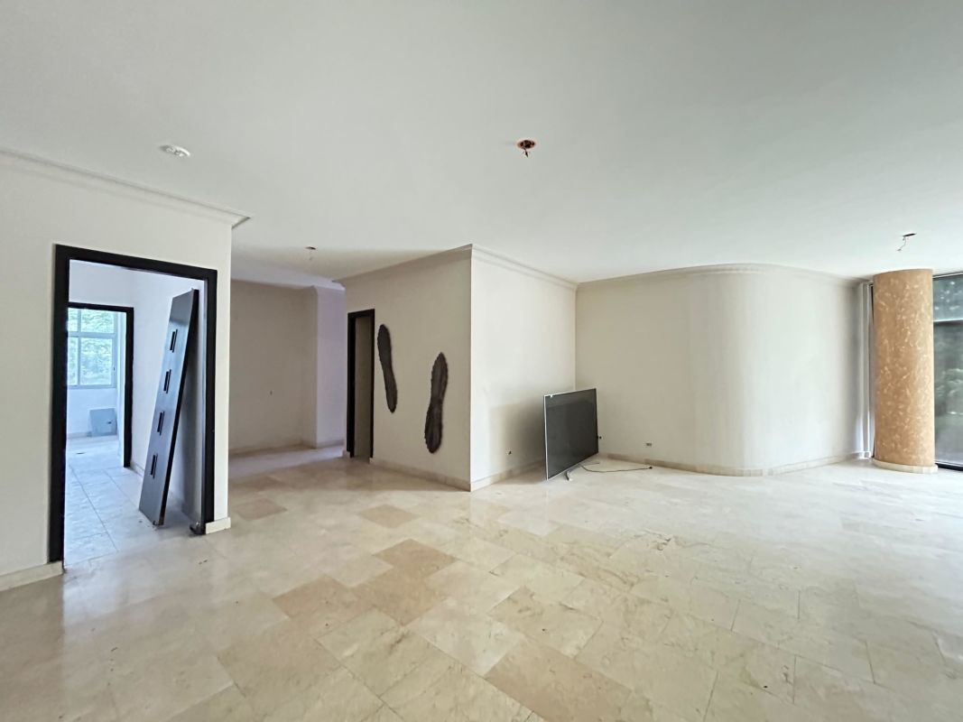 Open living dining space with large windows overlooking city skyline at PH The Bridge Amador.