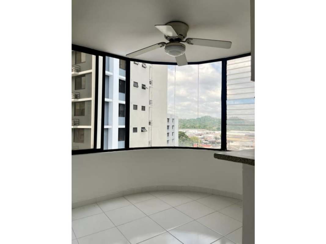 Modern enclosed balcony with large windows and ceiling fan overlooking El Cangrejo skyline