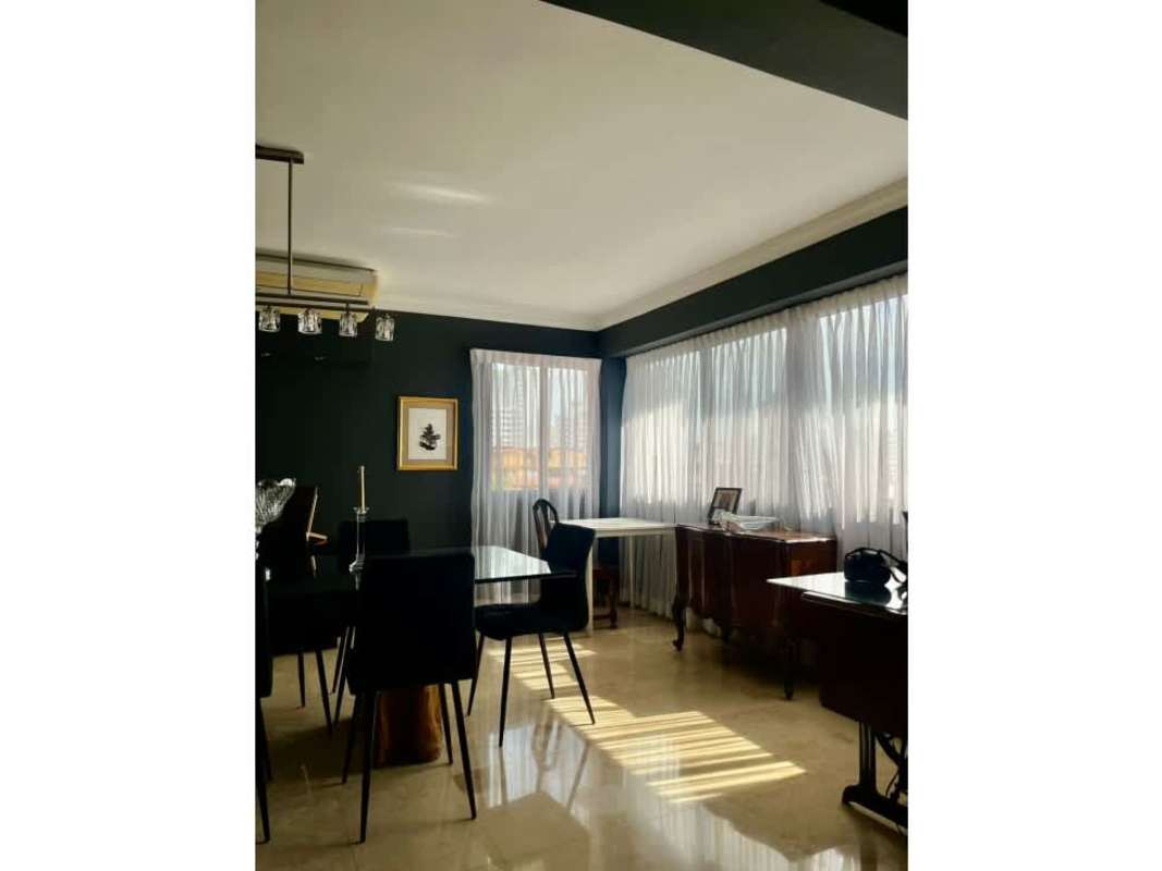 Elegant dining area with glass table, chandelier, large windows in PH Troy Panama El Cangrejo