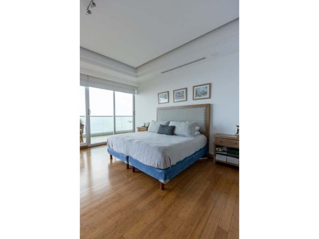 Spacious master bedroom with hardwood floors, floor-to-ceiling glass doors facing ocean in Ocean One Panama