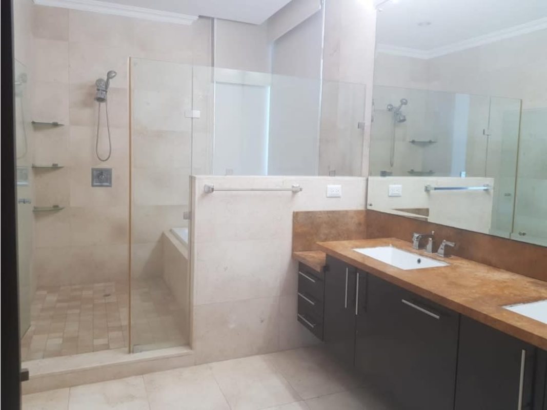 Luxury bathroom with double sinks, glass-enclosed shower, stone finishes at PH Ten Tower Costa del Este