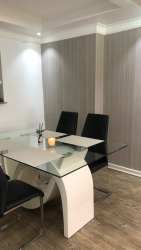 Dining room featuring glass table, accent wall with stone texture, PH Silver City Colón Panama