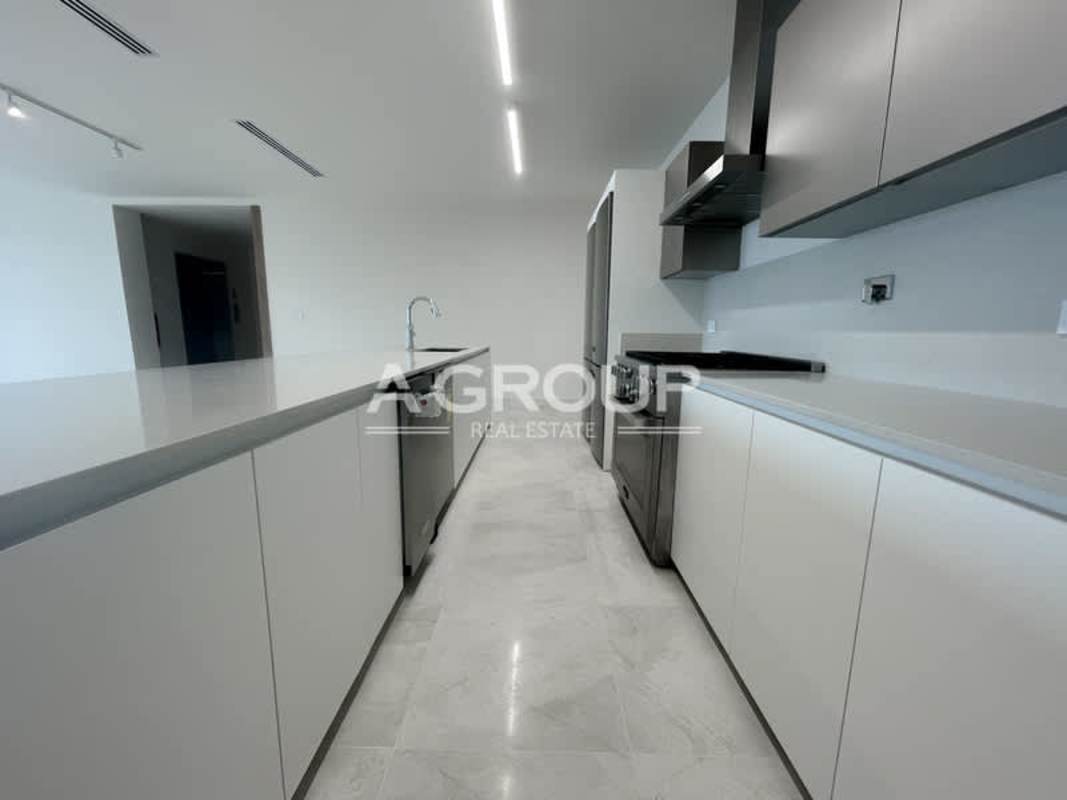 Modern minimal kitchen with peninsula and stainless appliances in Seascape Tower at Ocean Reef Panama