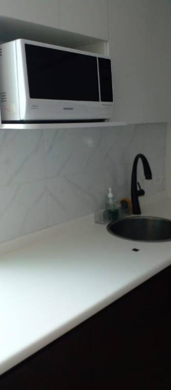 Minimalist kitchen with built-in stovetop, large window and black cabinets at PH Bella Vista Tower