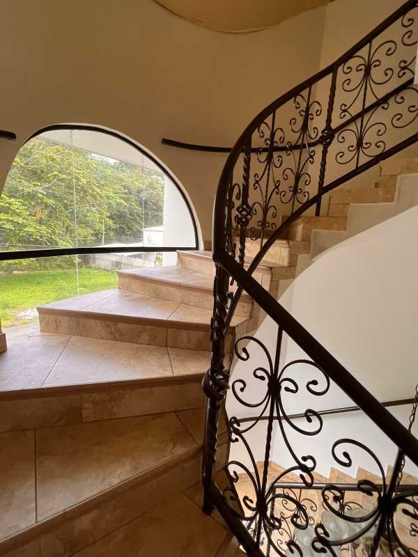 Decorative curved staircase with iron railing, arched window Curundu mansion Panama