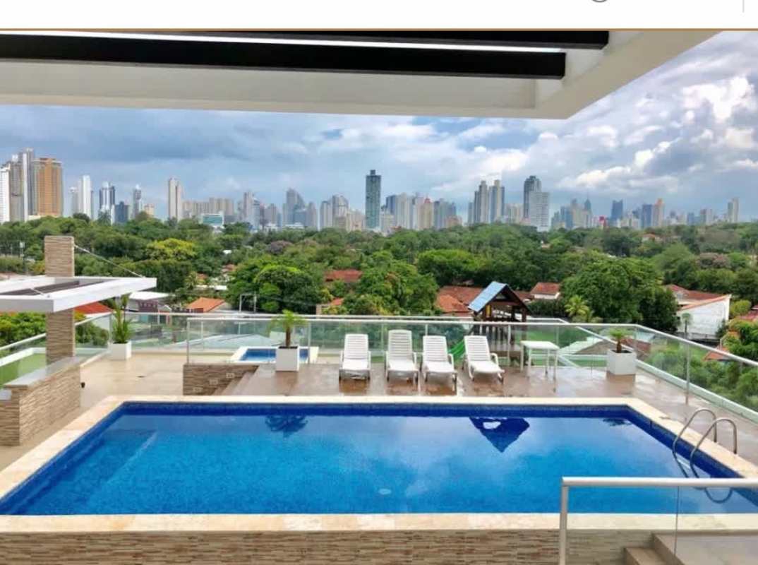 Infinity rooftop swimming pool with glass railings and city skyline Arena's Park Panama