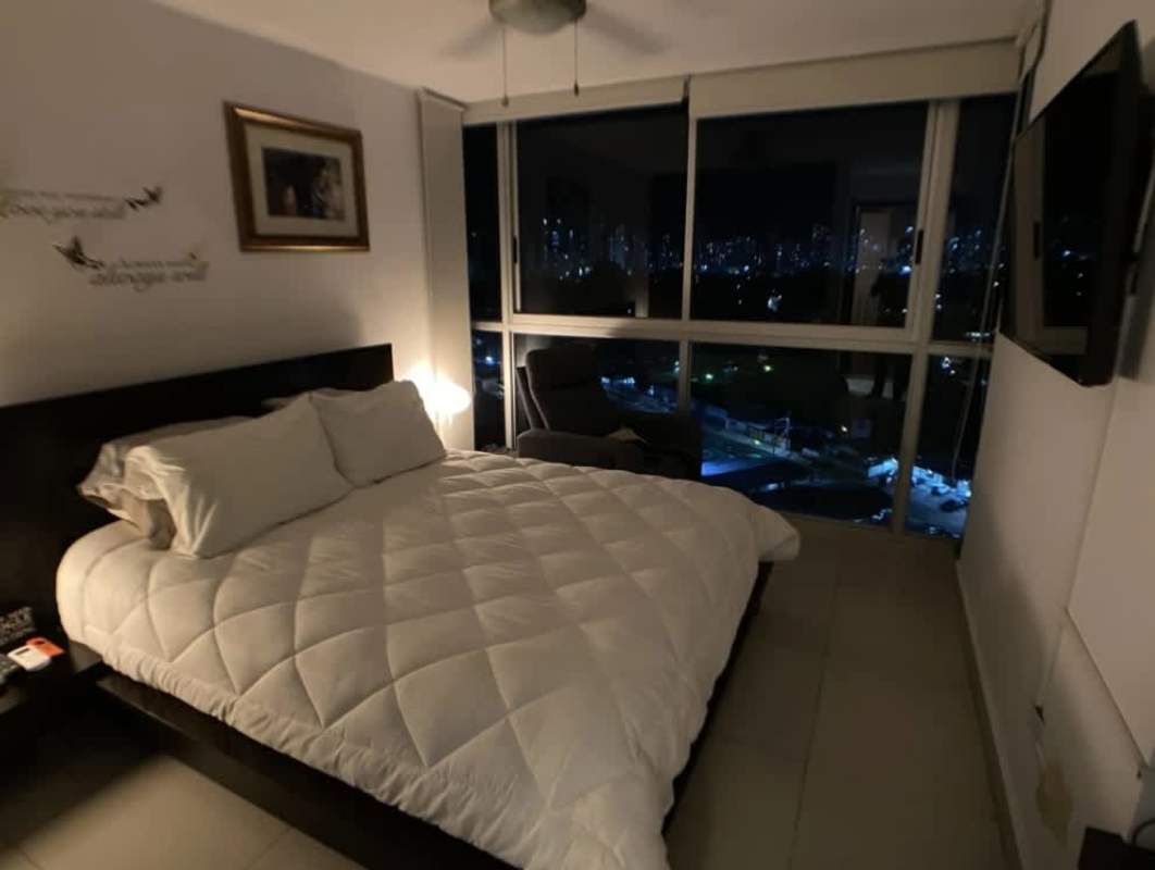 Master bedroom with cityscape night view, large windows, ceiling fan PH Arena's Park Panama