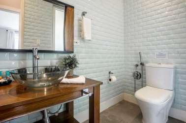 Modern bedroom with blue and white bedding, bedside tables, lamps, large window in Blue Venao Villa 32 Panama