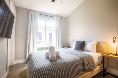 Bright contemporary bedroom with striped bedding, large window, vaulted ceiling Villa 32 Blue Venao Panama