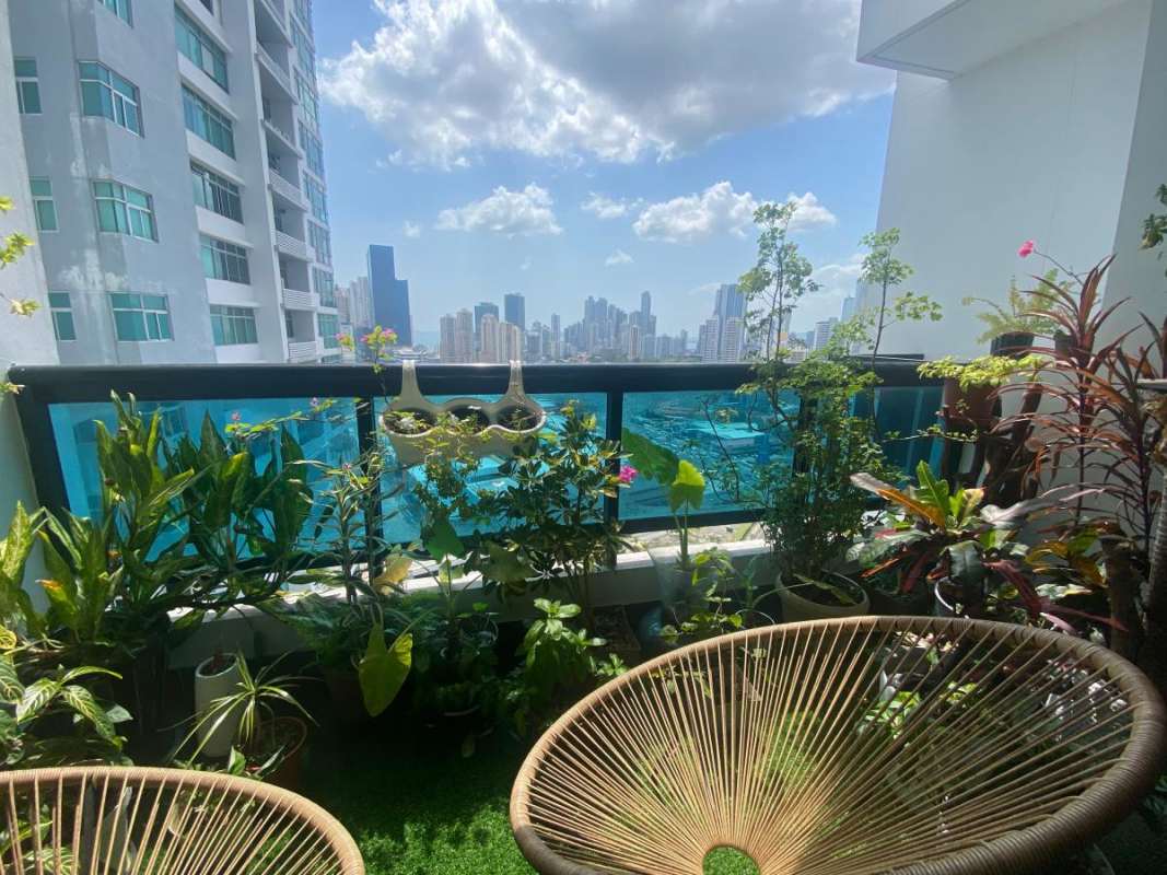 Balcony with lush plants, skyline view, glass railing PH Pacific Bay San Francisco Panama
