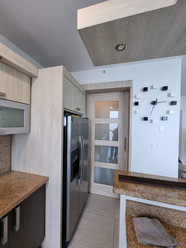 Contemporary kitchen with granite counters and stainless steel appliances in PH Le Mare Coco del Mar Panama City