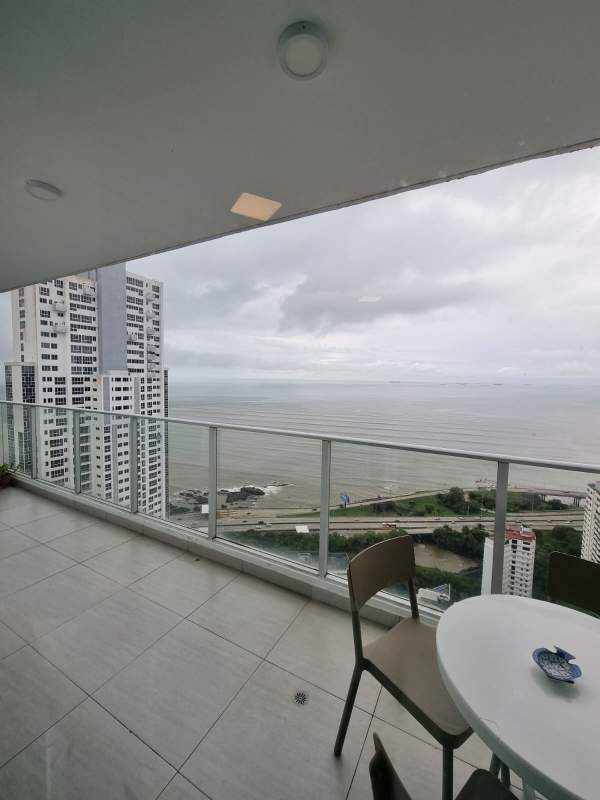 Open plan furnished living and dining room with ocean view balcony PH Le Mare Panama