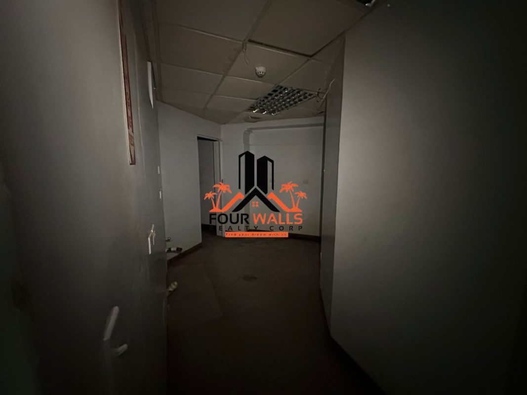 Hallway with drop ceiling and fluorescent lights inside commercial plaza Albrook