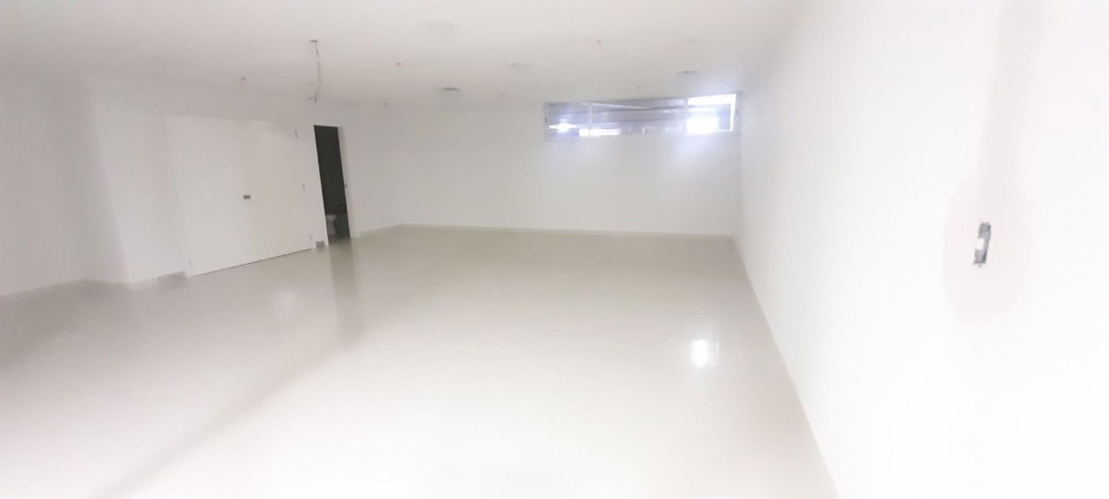 Reception lobby area in commercial office space with ceramic flooring and wood finishes Costa del Este Business Park