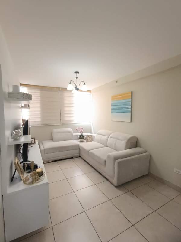 Open living room with sectional sofa, TV console, large window PH Vista Verde Panama