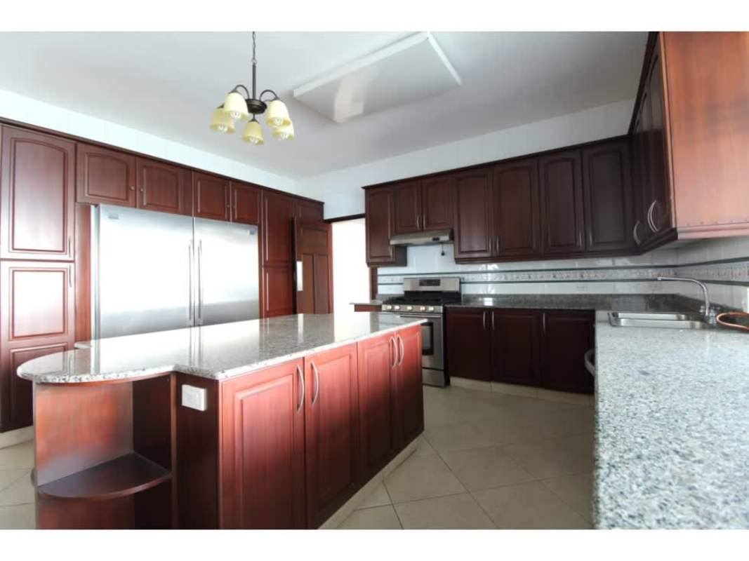 Traditional granite kitchen with center island stainless appliances dark wood cabinets in PH Coastal Tower Punta Paitilla