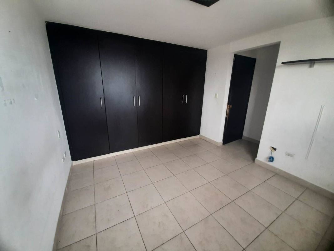 Empty minimalist bedroom with city-facing windows, light tile flooring in PH Vista Marina Tower Panama