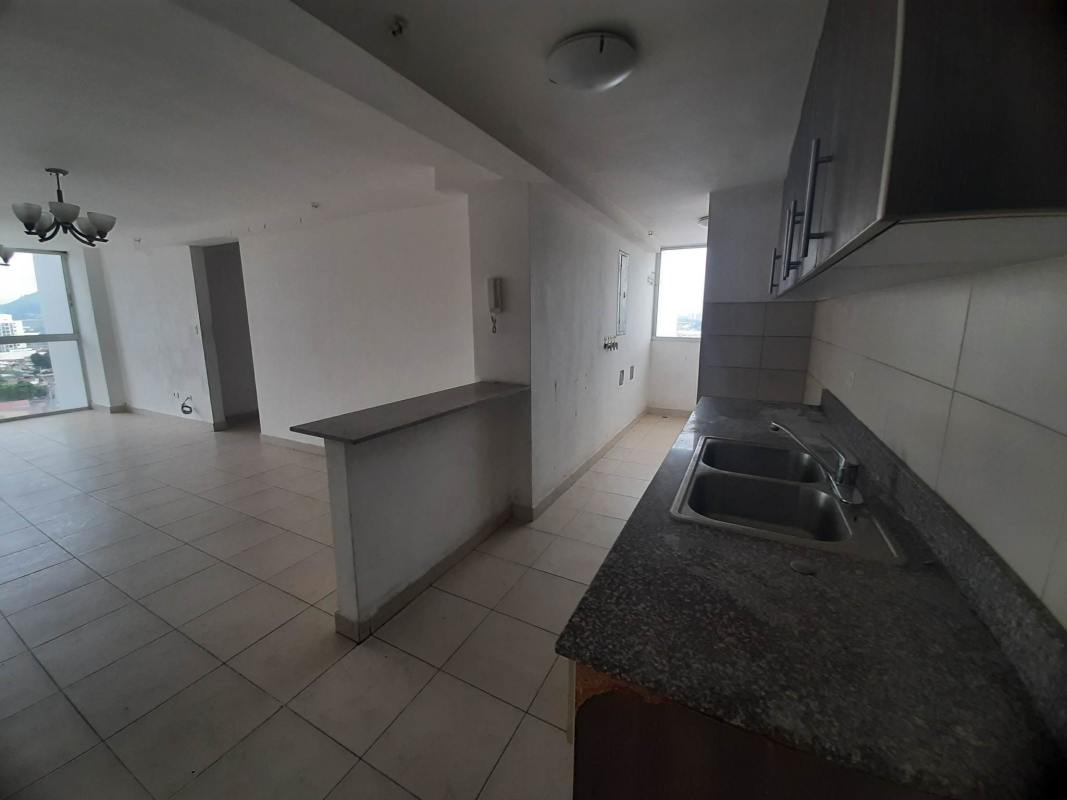 Modern kitchen open to living room with granite counters, double sink, large window in PH Vista Marina Tower