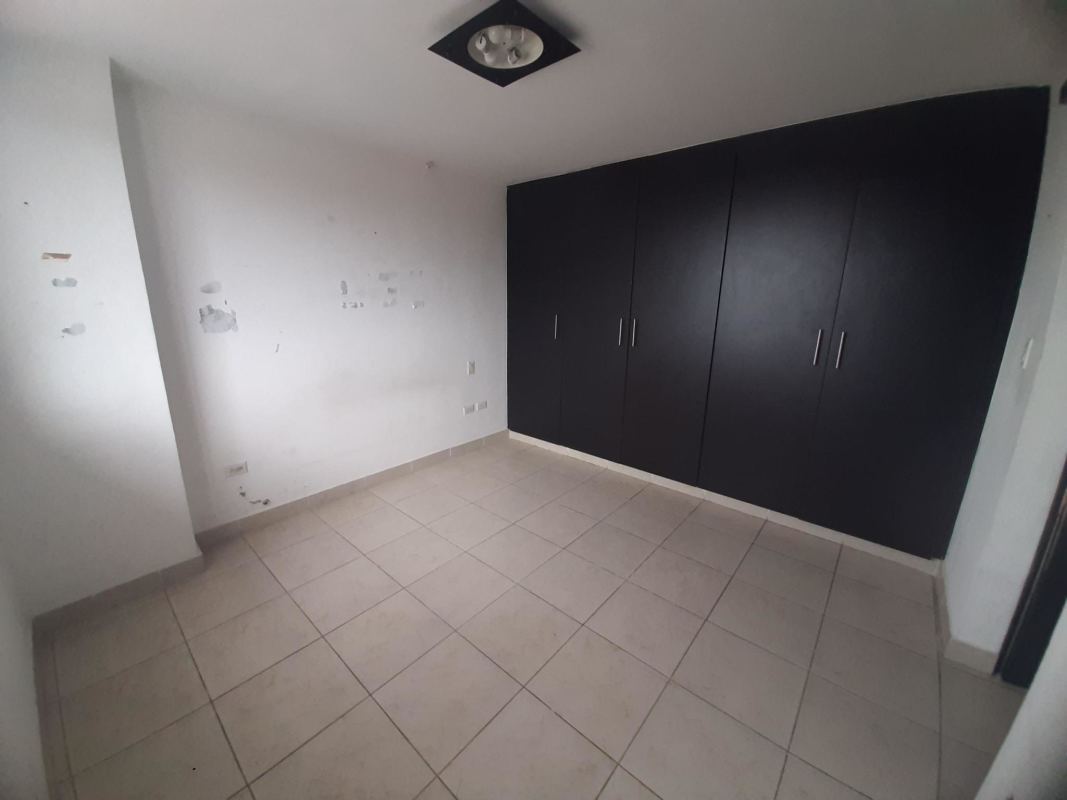 Empty bedroom with large black built-in closets, beige tiled floor PH Vista Marina Tower Panama