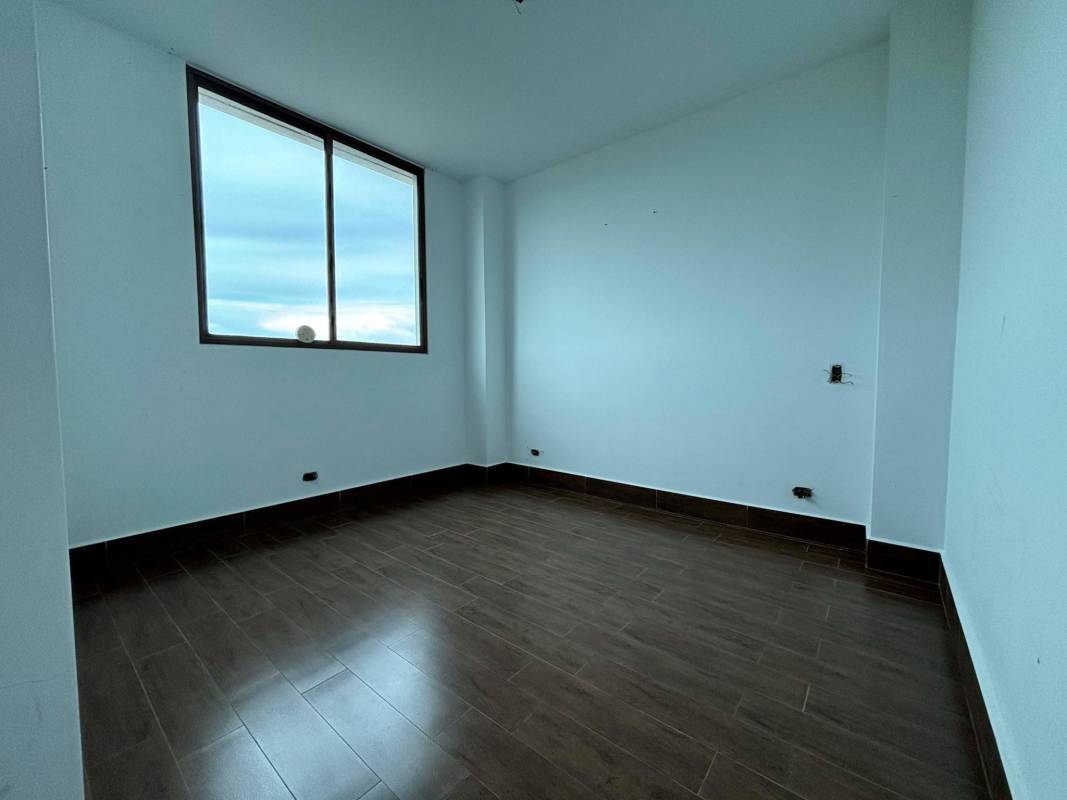 Bright bedroom with large window wood tile floor in PH Costamare Costa Sur Panama