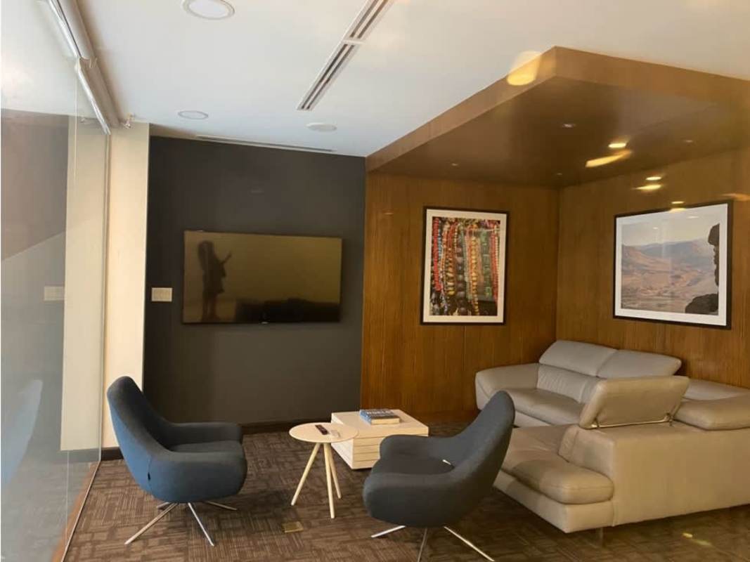 Reception lounge with sofa blue chairs TV in Llano Bonito Business Center Panama City